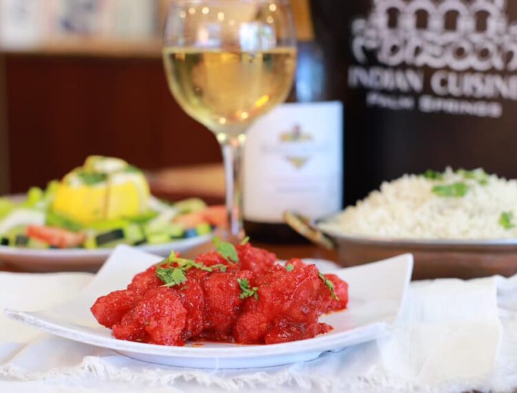 Indian food dish with glass of wine