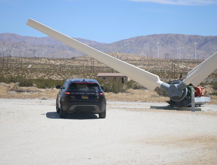 car parked near wind turbine blades